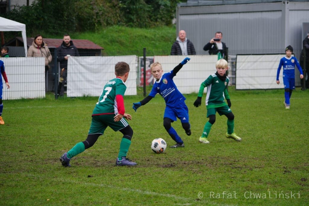 FC Wrocław Academy,zawody piłkarskie,młodzieżowa piłka nożna,ekstremalne warunki pogodowe,ulewa,rywalizacja drużyn,Wrocław,piłka nożna w deszczu,pasja do futbolu,sport młodzieżowy